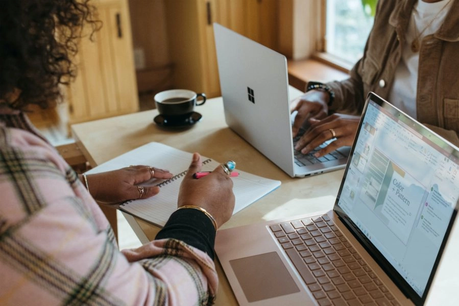 image: woman taking notes while working on computer