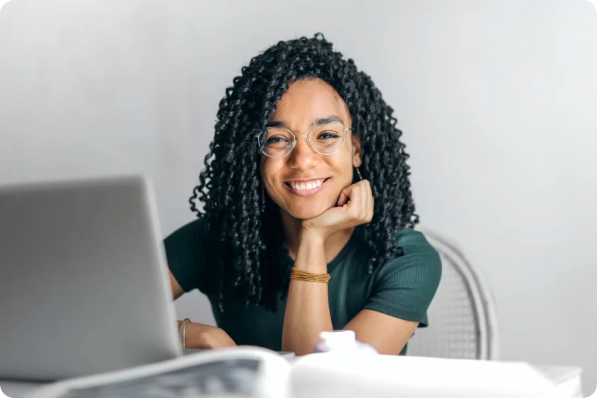 Woman in front of a laptop smiling at camera