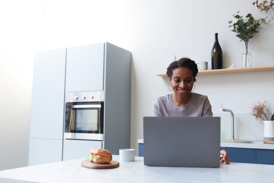 young woman working on her thinkific course at home. She is hiring fiverr freelancers to help with her workload.