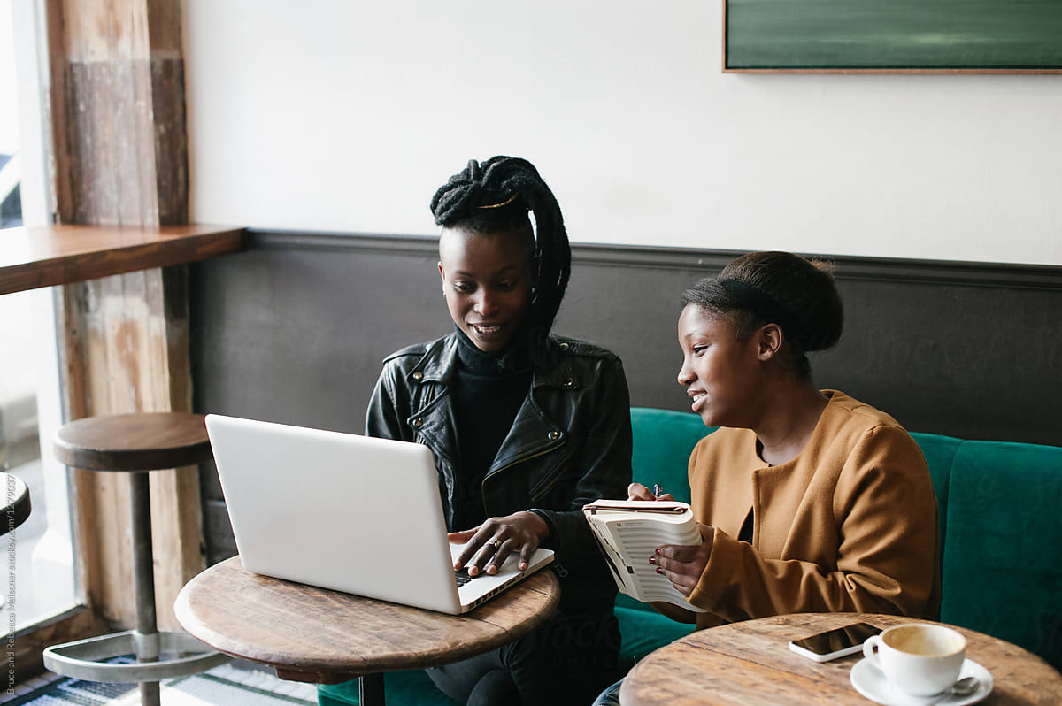 Woman coaching another woman on a laptop.