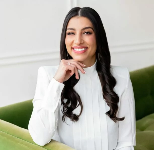 A photo of Yasmine Salem, intellectual property lawyer and founder of Coaches and Company, sitting on a green couch