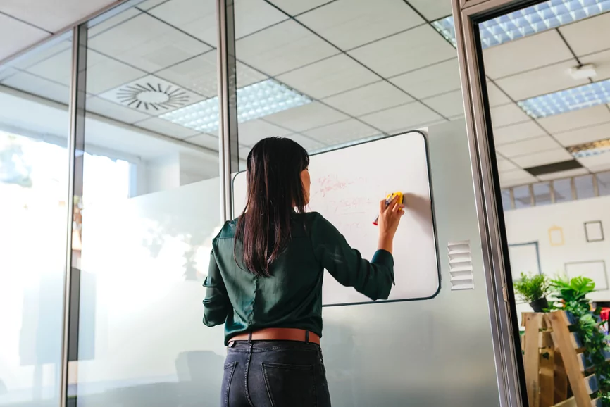 Woman creating customer journey map on a whiteboard