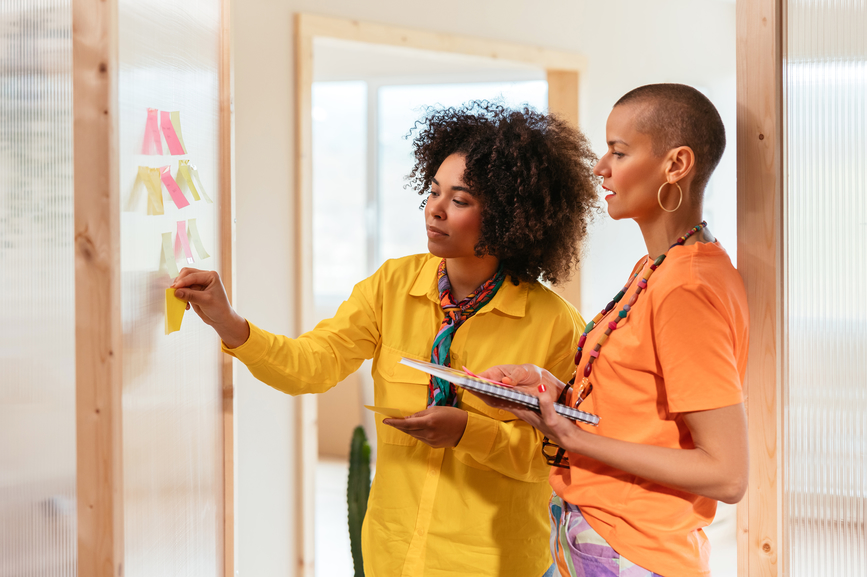 Female colleagues using sticknotes to define their user persona