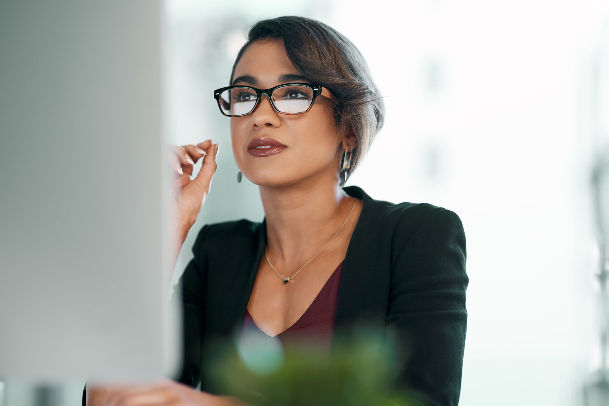 Computer, research and business woman in glasses reflection for reading, online review or editor analysis. Focused Latino person or professional worker in website editing or analytics on desktop pc.